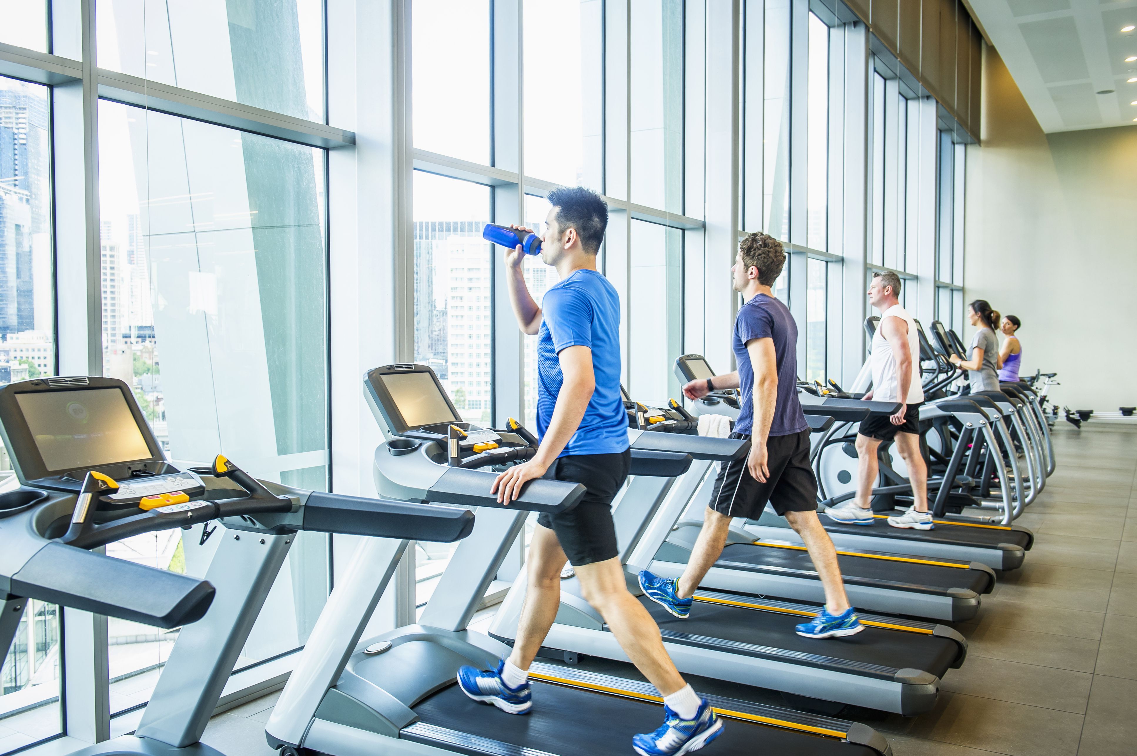 People working out on treadmills in gymnasium People working out on treadmills in gymnasium
