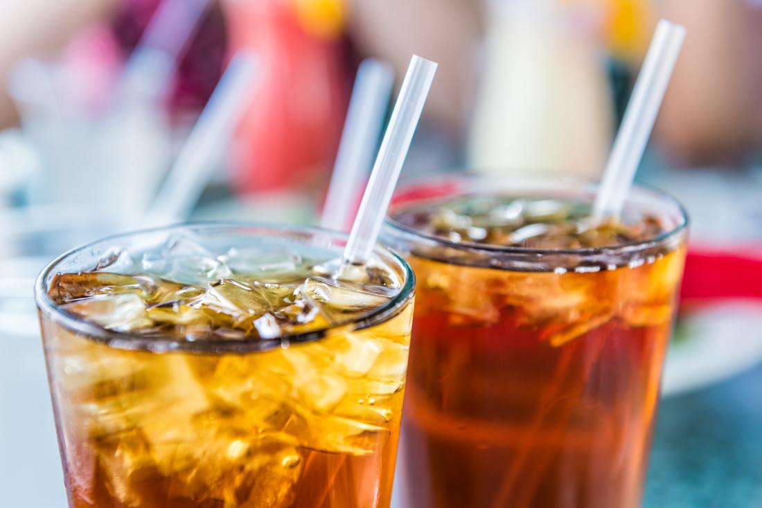 Drinks of ice tea or soda cola in glasses with straws