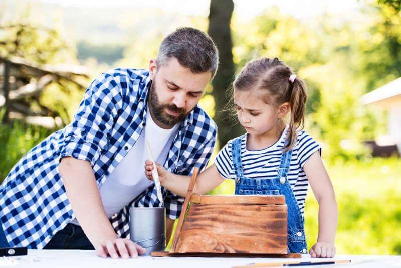 father-with-a-small-daughter-outside-making