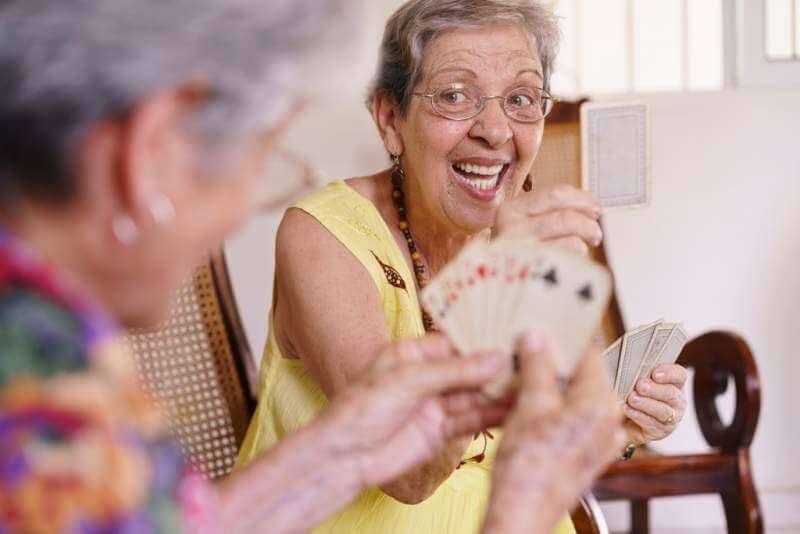 old-women-enjoy-playing-card-game-in-hospice