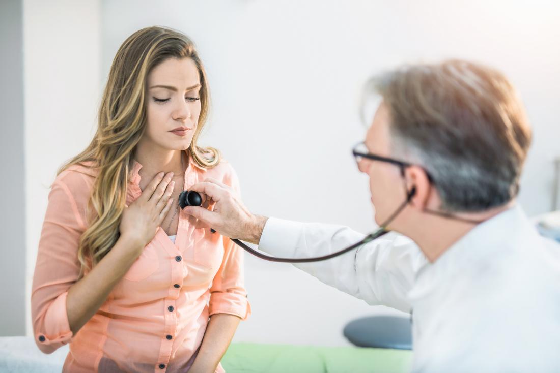 Female patient with shortness of breath being inspected by doctor using stethoscope