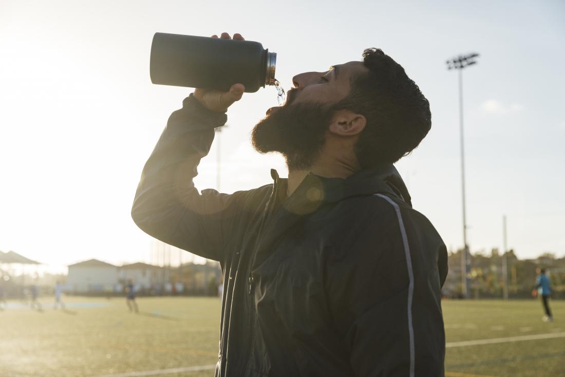 Athlete drinking water from bottle while playing sports