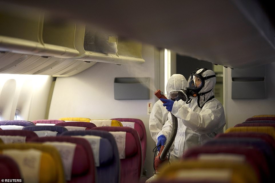 Thai Airways employees are pictured disinfecting an empty plane cabin at Suvarnabhumi International Airport in Bangkok today, January 28. Thailand has 14 confirmed coronavirus cases – the most outside of China
