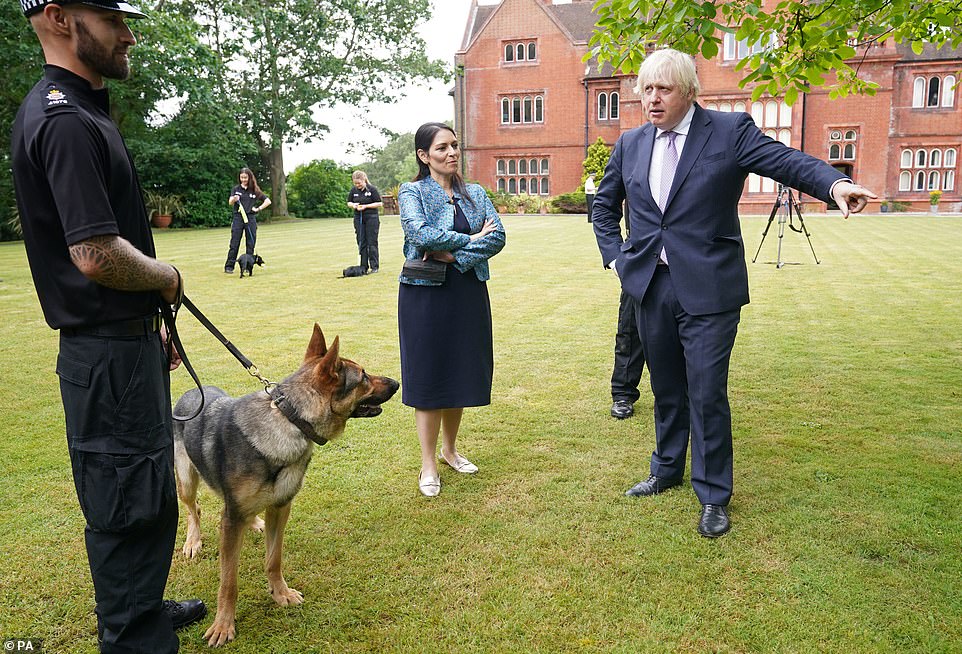 Mr Johnson (pictured at Surrey police HQ with Priti Patel today) is attempting to turn the focus on to his crime-fighting agenda, pledging to tag more offenders and make them clean up the streets